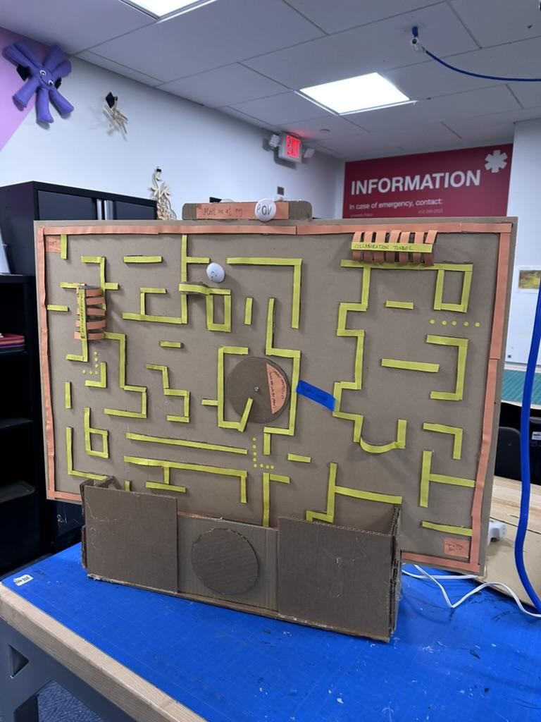 Mid-fidelity cardboard prototype with a rotating dial mechanism and labeled collaboration tunnel